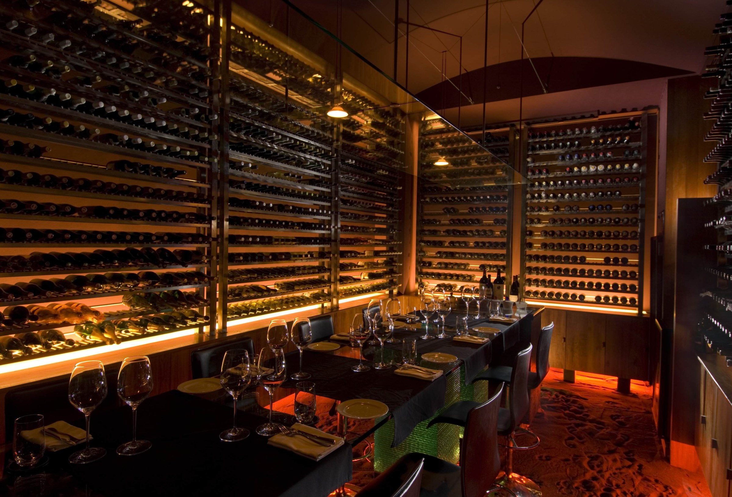 Warmly illuminated custom wine cellar dining room
